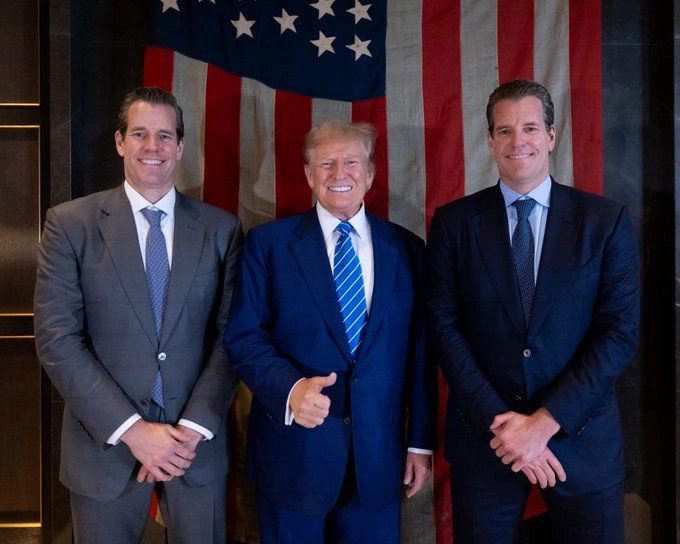 Gemini co-founders, Tyler and Cameron Winklevoss pose for a photo with US president, Donald Trump