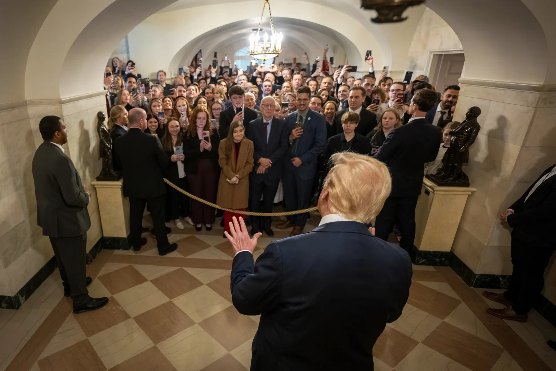 U.S. President Donald Trump stands in front of a crowd in a hall in the 白宫